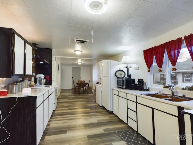 kitchen featuring white cabinets, washer / dryer, dark hardwood / wood-style flooring, and sink