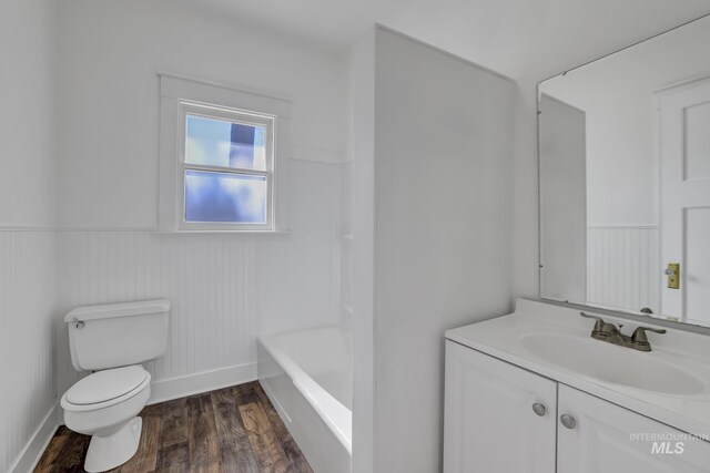 bathroom with vanity, wainscoting, wood finished floors, and toilet