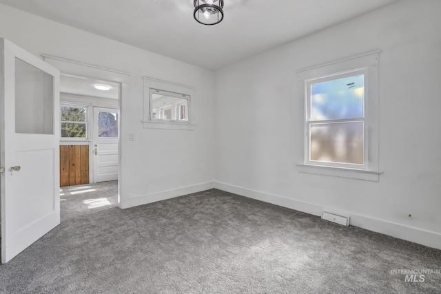 empty room featuring baseboards and carpet flooring