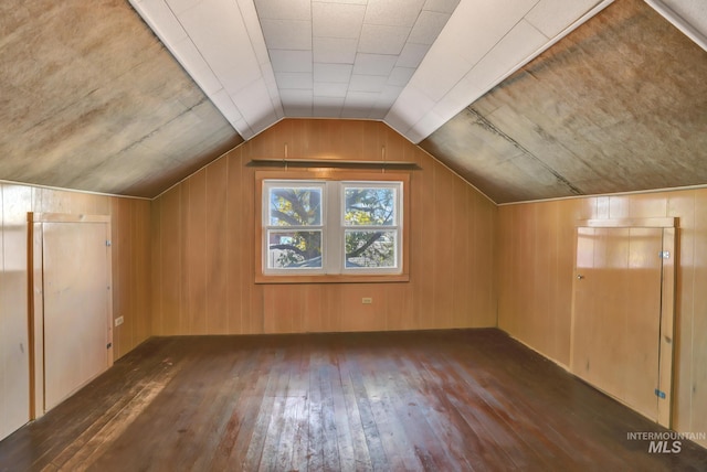 bonus room with lofted ceiling, wood walls, and wood-type flooring