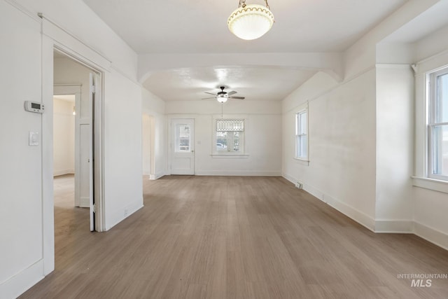 empty room featuring light wood-type flooring, ceiling fan, and baseboards