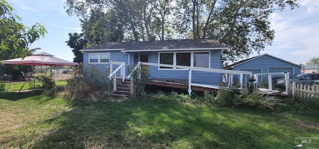 back of property with a yard and a wooden deck