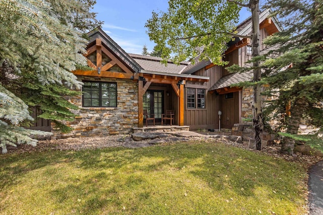 view of front of house featuring board and batten siding, stone siding, and a front lawn