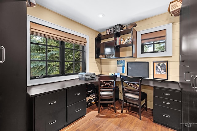 home office with built in study area and wood finished floors