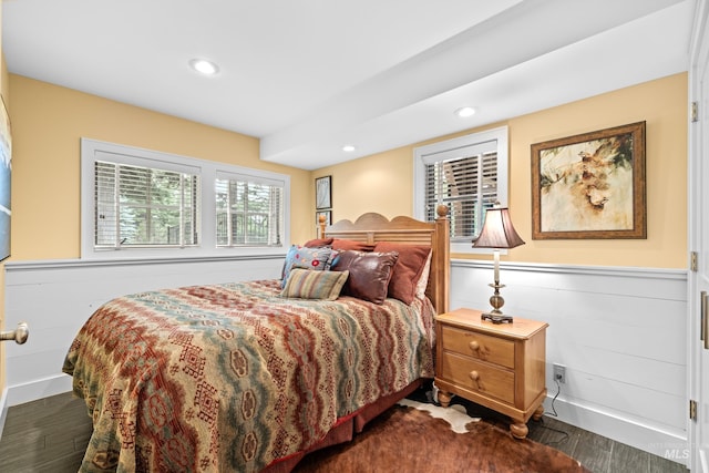 bedroom with a wainscoted wall, dark wood-style flooring, and recessed lighting