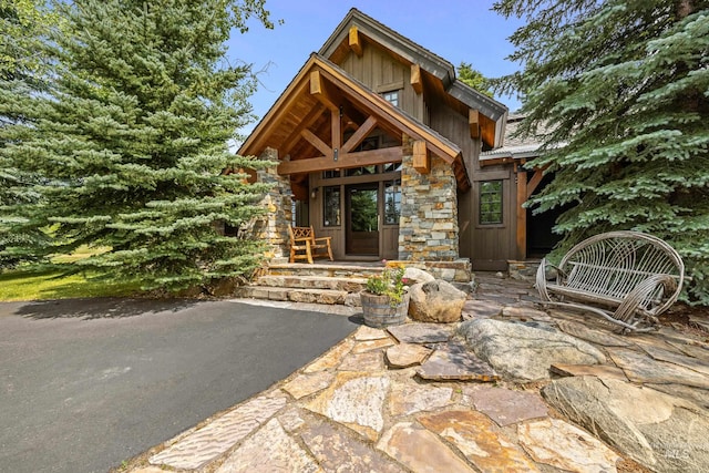 property entrance featuring stone siding and board and batten siding