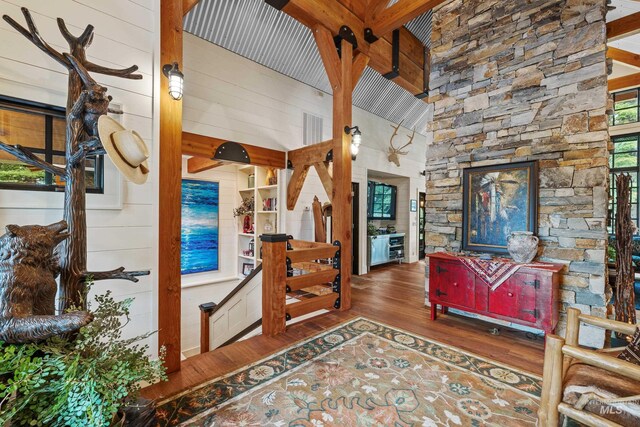 living room with hardwood / wood-style floors, beamed ceiling, high vaulted ceiling, and a healthy amount of sunlight