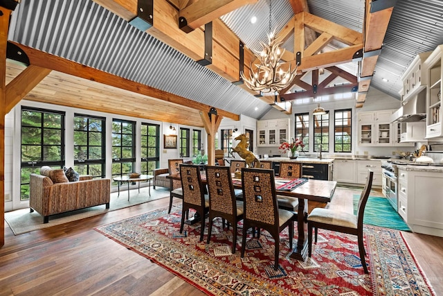 dining area featuring high vaulted ceiling, beam ceiling, a chandelier, and wood finished floors