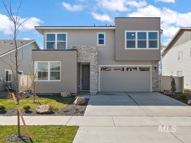 664 E Lockhart St, Meridian, ID 83646 - view of front of home with an attached garage, driveway, stone siding, and fence
