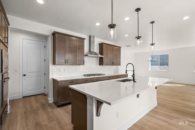 664 E Lockhart St, Meridian, ID 83646 - kitchen featuring recessed lighting, stainless steel appliances, wall chimney range hood, a sink, and light wood-type flooring
