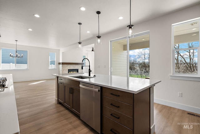 664 E Lockhart St, Meridian, ID 83646 - kitchen with stainless steel dishwasher, a sink, light wood finished floors, a fireplace, and visible vents