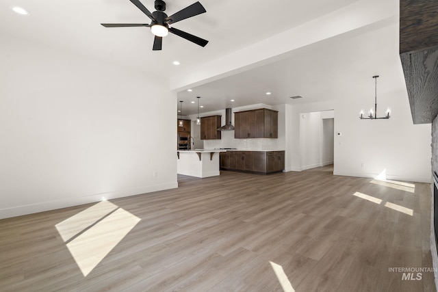664 E Lockhart St, Meridian, ID 83646 - unfurnished living room with baseboards, ceiling fan with notable chandelier, light wood-type flooring, and recessed lighting