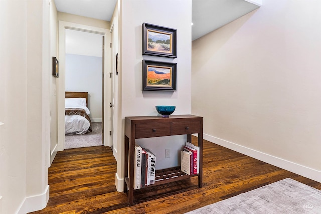 hallway featuring wood finished floors and baseboards