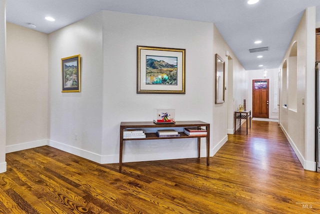 corridor with wood finished floors, baseboards, and recessed lighting
