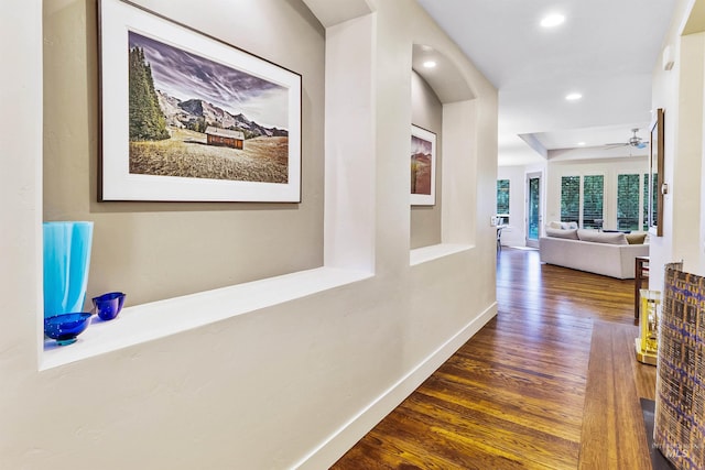 corridor featuring wood finished floors, recessed lighting, and baseboards