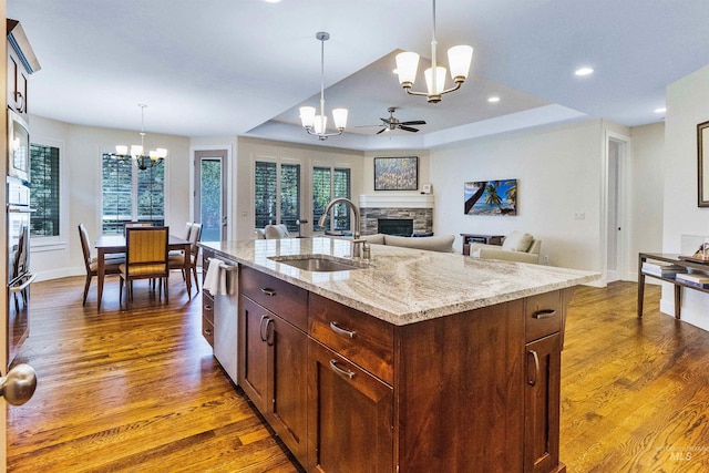kitchen with a chandelier, a sink, dark wood finished floors, a fireplace, and recessed lighting