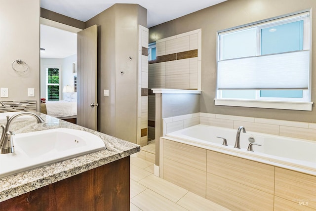 full bath featuring ensuite bathroom, a garden tub, a walk in shower, tile patterned flooring, and vanity