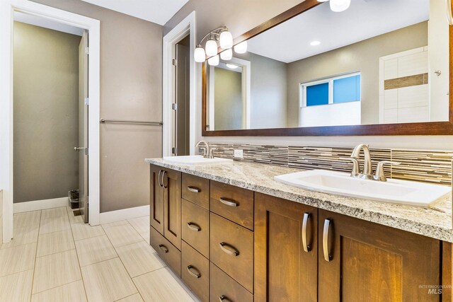 bathroom featuring baseboards, double vanity, recessed lighting, and tile patterned floors