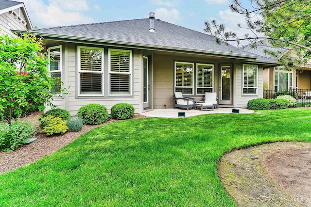 rear view of property with a shingled roof and a patio area