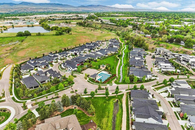 aerial view of property and surrounding area with a water and mountain view and nearby suburban area