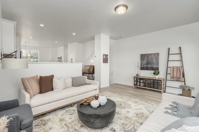 living room featuring light wood-type flooring and a notable chandelier