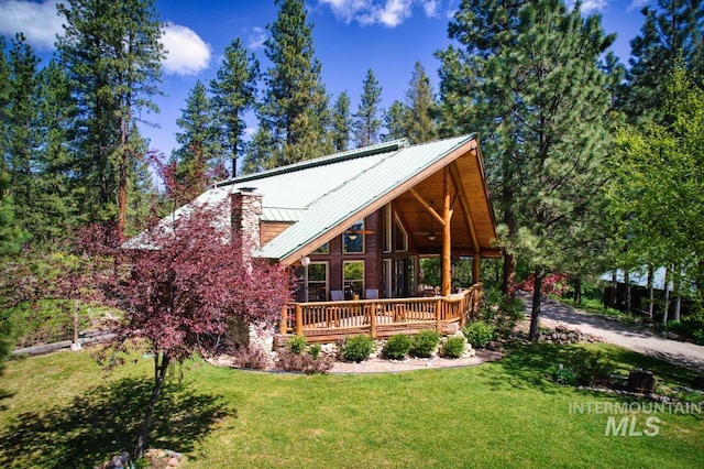 49 Sunny Ridge Rd, Garden Valley, ID 83622 - view of front of house with a front lawn, a deck, metal roof, and a chimney