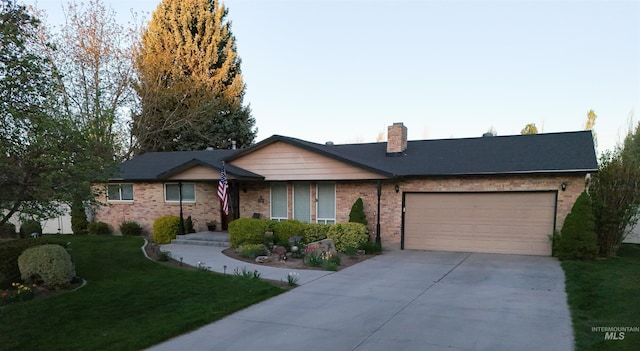 ranch-style home featuring a chimney, brick siding, a front lawn, concrete driveway, and an attached garage