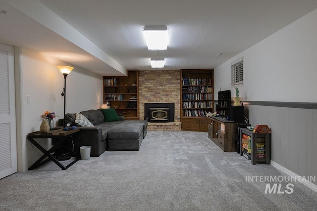 carpeted living room with built in features and a brick fireplace