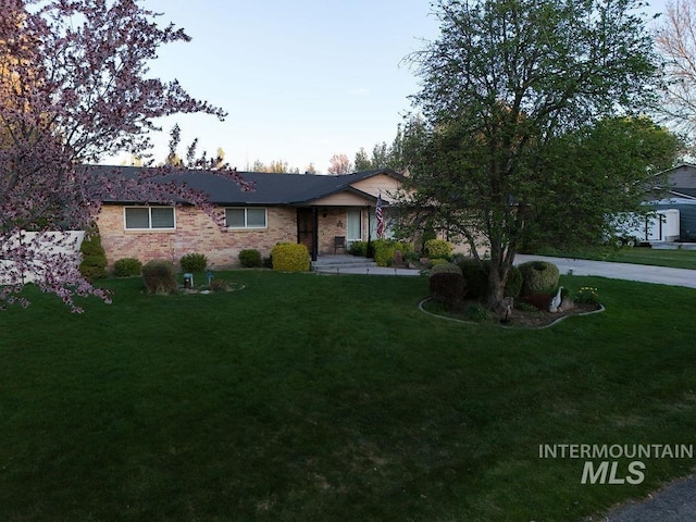 ranch-style house featuring a front yard and brick siding