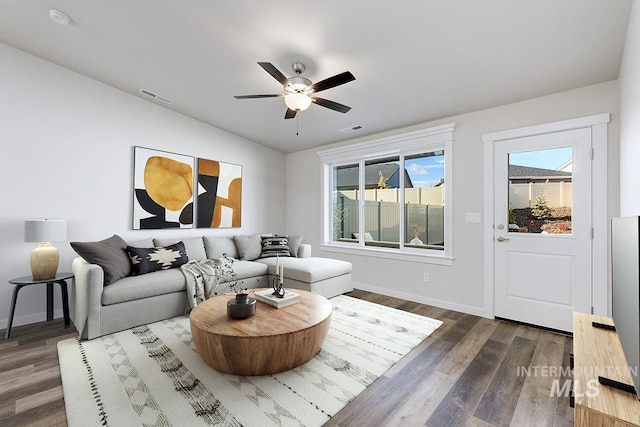 living room featuring lofted ceiling, ceiling fan, and dark wood-type flooring