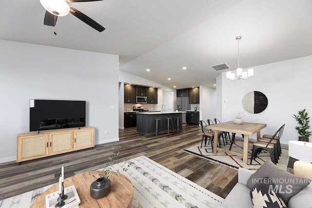 living room featuring dark hardwood / wood-style flooring, ceiling fan with notable chandelier, and lofted ceiling