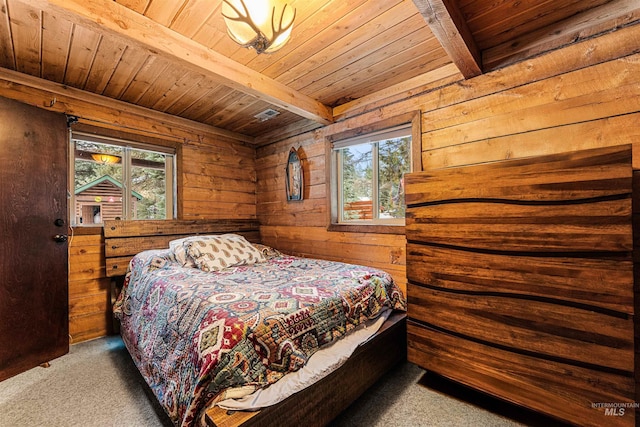 bedroom with beamed ceiling, wood walls, wooden ceiling, and multiple windows