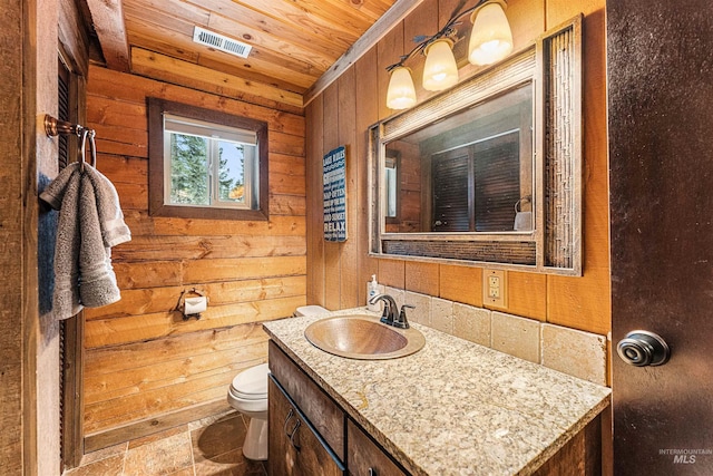 bathroom featuring vanity, toilet, wooden ceiling, and wooden walls