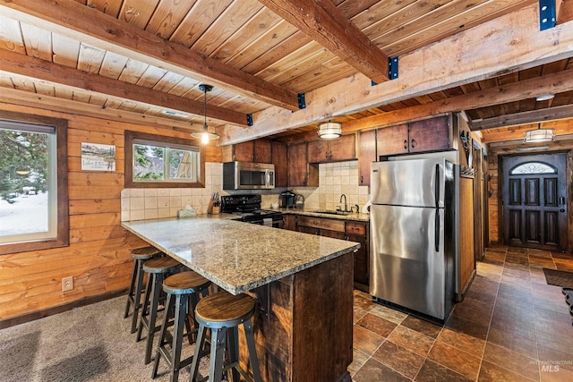 kitchen with wood walls, sink, beam ceiling, kitchen peninsula, and stainless steel appliances