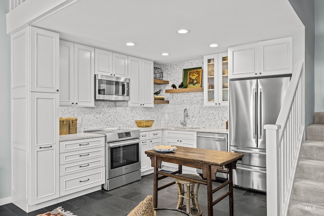 2226 Bonne Vie Condo Dr, Sun Valley, ID 83353 - kitchen featuring appliances with stainless steel finishes, a sink, recessed lighting, white cabinetry, and tasteful backsplash