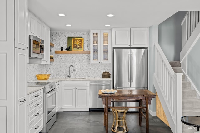 2226 Bonne Vie Condo Dr, Sun Valley, ID 83353 - kitchen with appliances with stainless steel finishes, a sink, white cabinetry, light stone counters, and recessed lighting