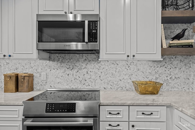 2226 Bonne Vie Condo Dr, Sun Valley, ID 83353 - kitchen with stainless steel appliances, tasteful backsplash, white cabinetry, and light stone countertops