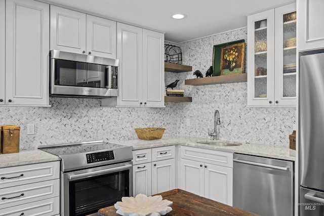 2226 Bonne Vie Condo Dr, Sun Valley, ID 83353 - kitchen featuring stainless steel appliances, a sink, tasteful backsplash, and glass insert cabinets