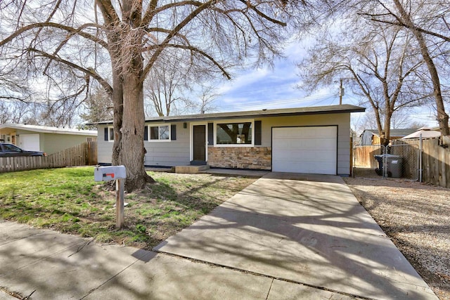 ranch-style house featuring driveway, an attached garage, and fence