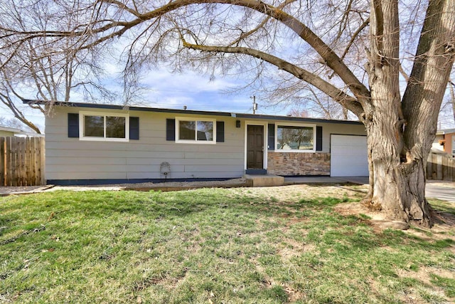 ranch-style home with fence, a front yard, driveway, stone siding, and an attached garage