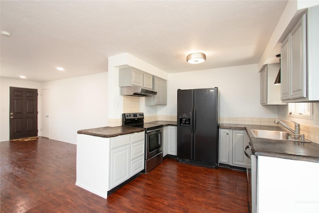 kitchen featuring dark countertops, black fridge, electric stove, and a sink