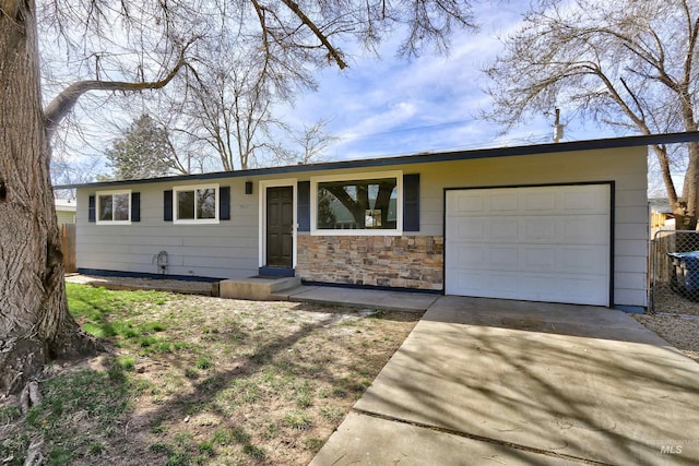 ranch-style house featuring fence, a garage, and driveway