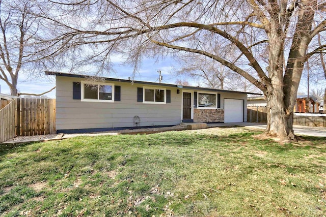 ranch-style home featuring a front yard, fence, a garage, and driveway