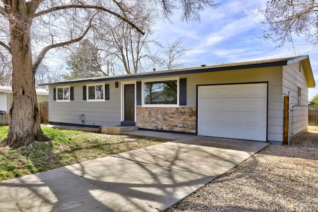 ranch-style house featuring an attached garage, fence, and driveway