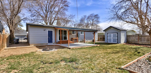 rear view of house featuring a storage shed, an outdoor structure, a yard, and a fenced backyard