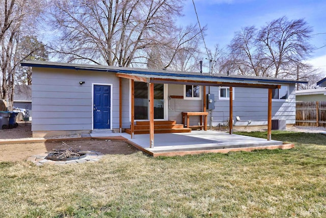 rear view of house with a lawn, entry steps, and fence