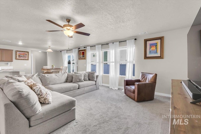 1266 S Wiston Ave, Kuna, ID 83634 - carpeted living room featuring ceiling fan, a textured ceiling, and baseboards