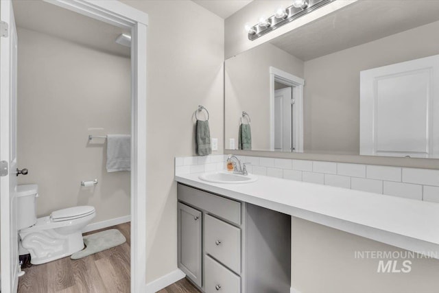1266 S Wiston Ave, Kuna, ID 83634 - bathroom with toilet, wood finished floors, vanity, backsplash, and baseboards