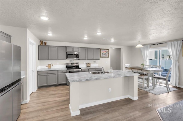 1266 S Wiston Ave, Kuna, ID 83634 - kitchen featuring stainless steel appliances, gray cabinets, a textured ceiling, a sink, and baseboards