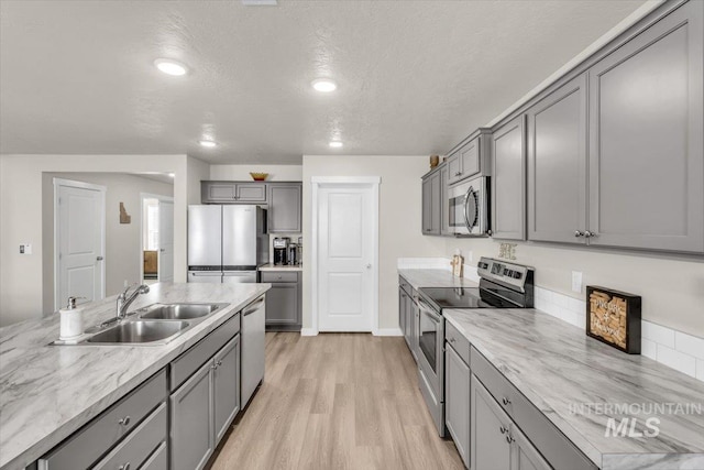1266 S Wiston Ave, Kuna, ID 83634 - kitchen with appliances with stainless steel finishes, gray cabinets, a sink, light wood finished floors, and recessed lighting
